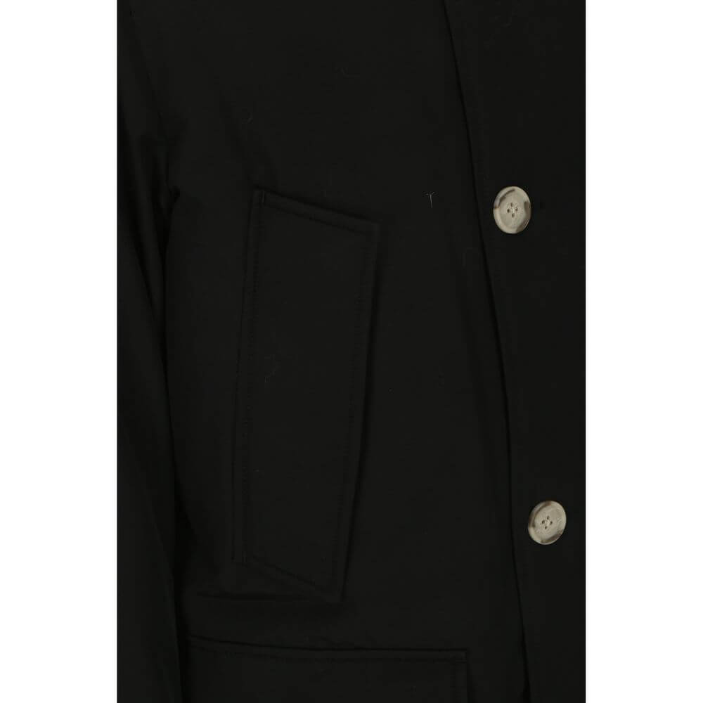 Close-up of Woolrich Black Cotton Parka with front button closure and side patch pocket detail.