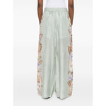 Zimmermann Coco trousers in sage green with floral print and elasticated waistband, side pockets, back view.